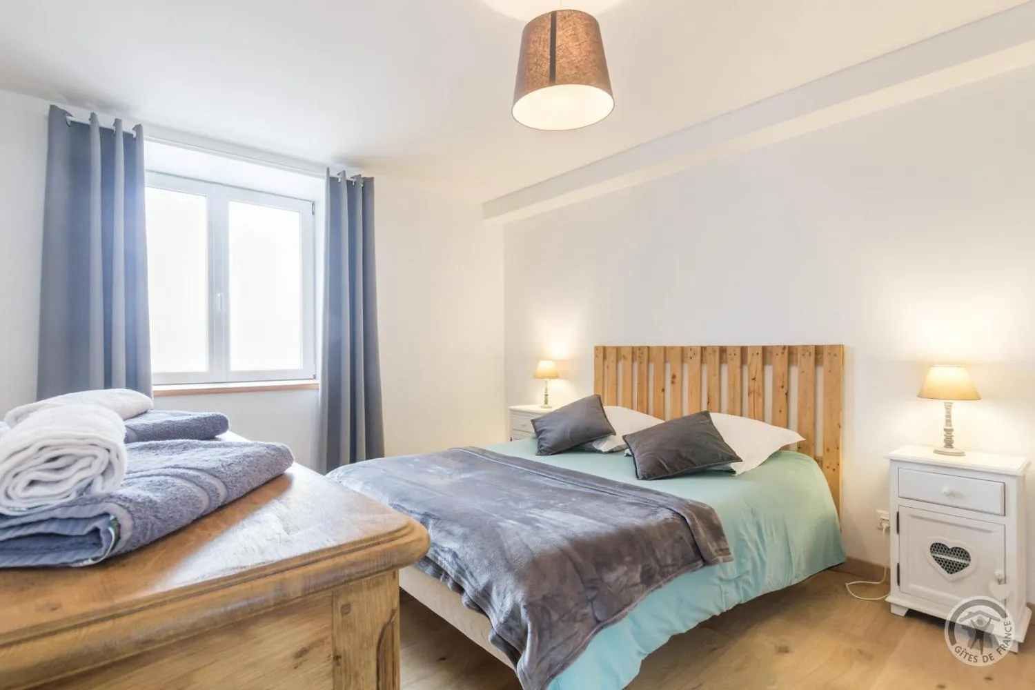 Le lit double et sa tête de lit en bois